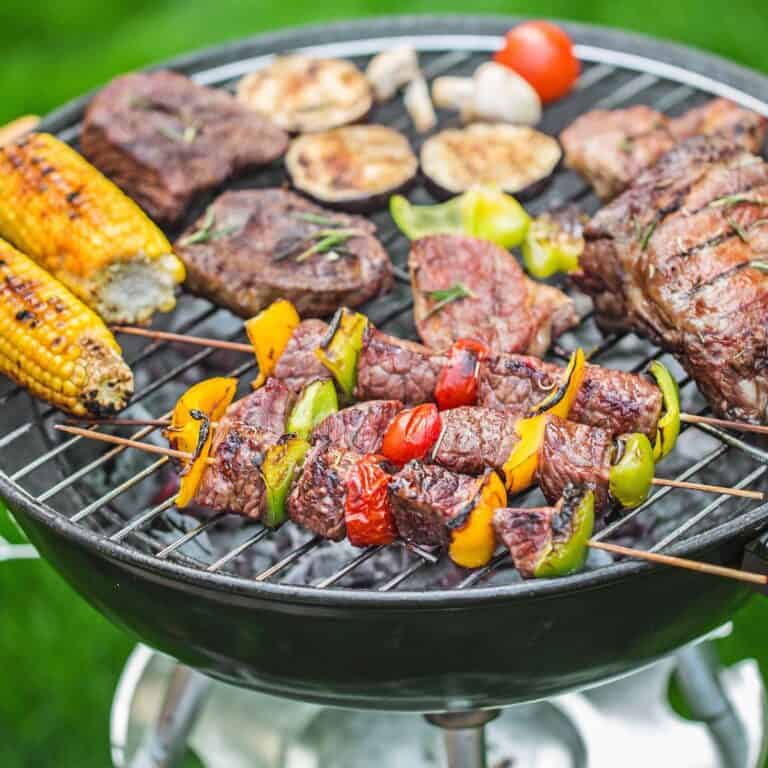 A grill with a bunch of food being cooked.